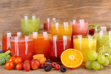 Glasses of tasty fresh juice, on wooden table.