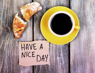 Composition of coffee, fresh croissant and paper card