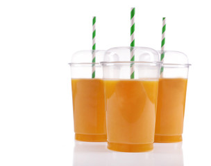 Orange juice in fast food closed cups with tubes isolated