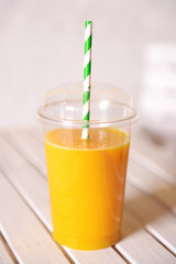 Orange juice in fast food closed cup with tube