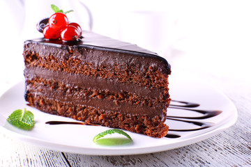 Delicious chocolate cake on plate on table on light background