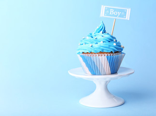 Delicious cupcake with inscription on blue background