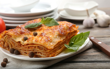 Portion of tasty lasagna on wooden table