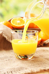 Pouring orange juice from glass carafe,