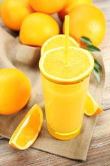 Glass of orange juice with straw and slices