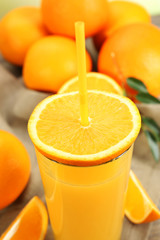 Glass of orange juice with straw and slices