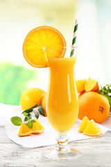 Glass of orange juice with straw and slices