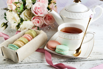Composition with colorful macaroons, teapot and up of tea