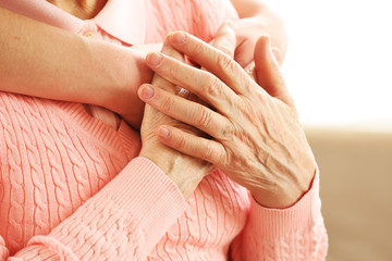 Old and young hands hug, closeup