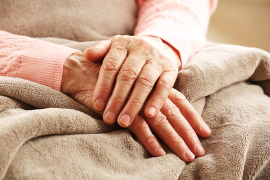 Hands of adult woman on light background, closeup