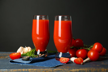Glasses of tasty tomato juice and fresh tomatoes