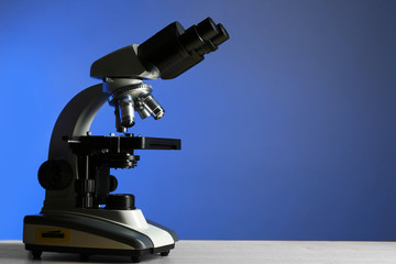 Fototapeta na wymiar Microscope on table, on color background