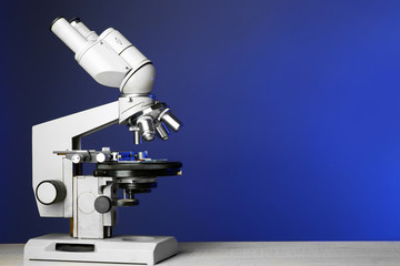 Microscope on table, on blue background