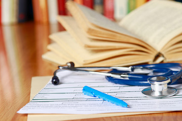 An image of a book, prescription and pen lying on the desk
