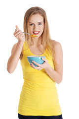 Happy blonde woman eating cereals