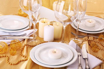 Beautiful holiday table setting in white and gold color