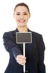 Smiling businesswoman holding small empty board