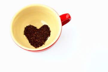 Heart, made of Rooibos tea leaves, in a mug.