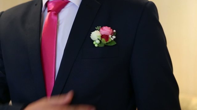 the groom corrects the buttonhole