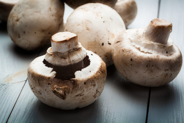 White button mushrooms on a wooden blue table
