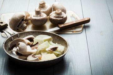 Sliced mushrooms with onion on a pan