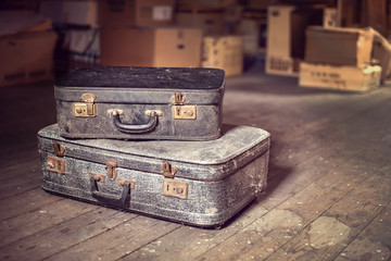 Old vintage suitcases in a dusty attic - obrazy, fototapety, plakaty