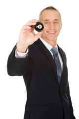 Businessman holding black billiard ball