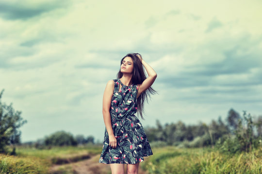 beautiful brunette in a field on a sunny day
