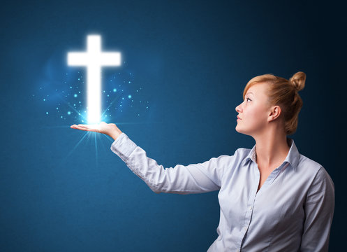 Glowing cross in the hand of a businesswoman