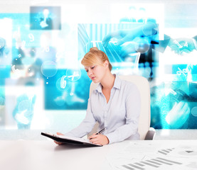 Business person at desk with modern tech images at background