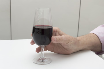 Old woman hand holding a glass of wine