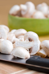 Cutting  white mushrooms with a kitchen knife