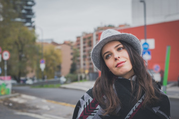 Fototapeta premium Beautiful young brunette posing in the city streets