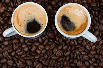 Fresh creamy expresso over roasted coffee beans background