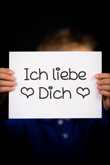 Child holding sign with German words Ich liebe Dich - I Love You