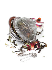 Green herbal tea with dried flowers in tea strainer