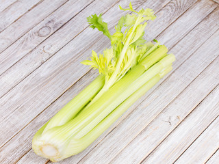 Organic vegetables - celery with leaves on wooden background