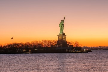 Naklejka premium The silhouette of Statue of Liberty in New York City at sunrise