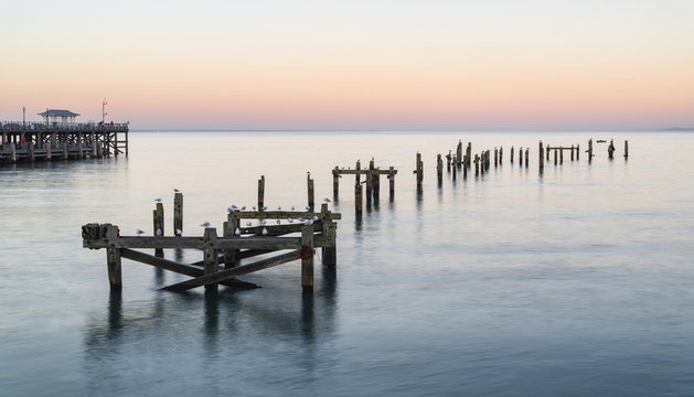 Peaceful concept landscape image of smooth sea and pier ruins