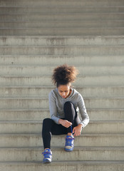 Fototapeta na wymiar Young sports woman tying shoelaces on steps
