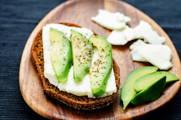 sandwich of rye bread with avocado and goat cheese