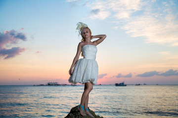 bride on a tropical beach with the sunset in the background