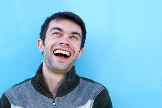 Close up face portrait of a young man laughing