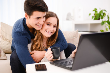 young couple at home playing on internet with a computer