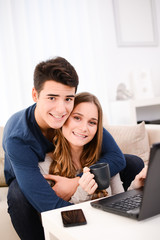 happy young couple together at home playing with a computer