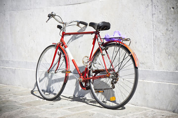 Fototapeta na wymiar Red bicycle against a marble wall