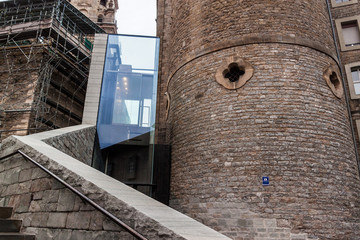 Stone buildings and a glass elevator