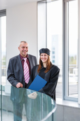 Pretty female university graduate with her happy and proud fathe