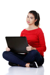 Naklejka premium Front view woman sitting cross-legged with laptop