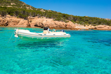 Naklejka na ściany i meble Small boat in turquoise clear sea
